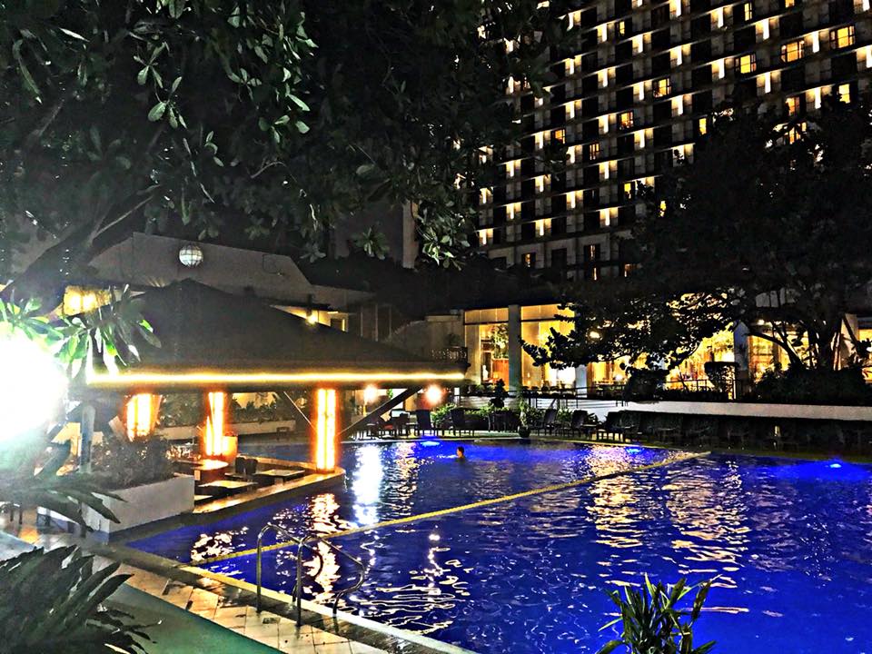 Outdoor swimming pool at The Manila Hotel illuminated at night